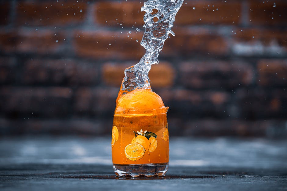 Freshly squeezed orange juice cascading into a crystal glass, surrounded by vibrant, ripe oranges